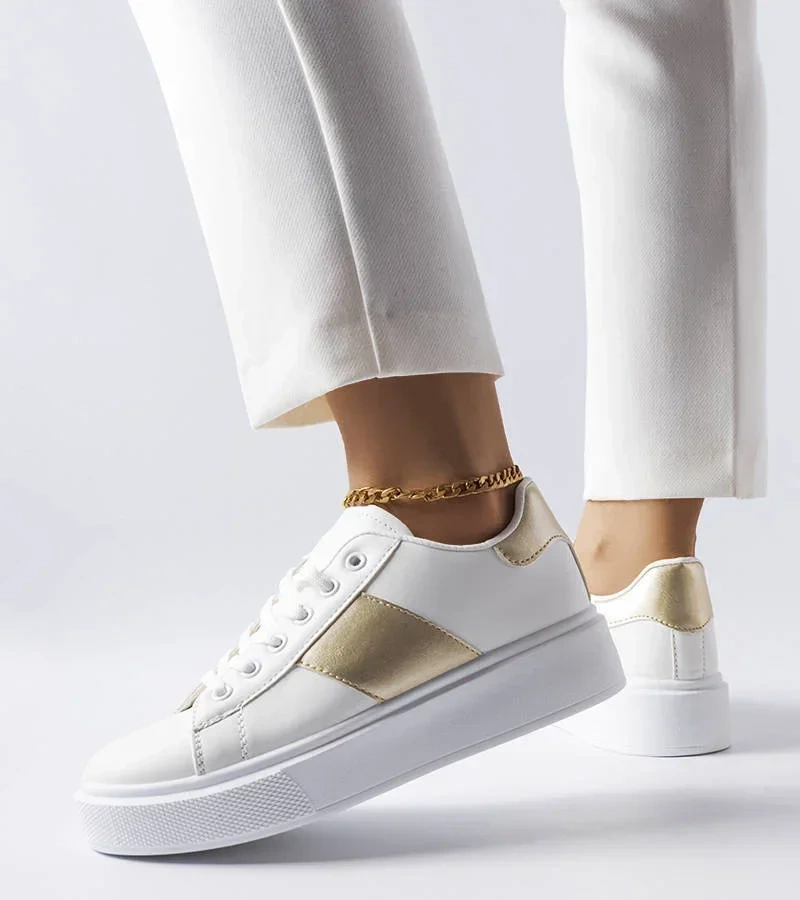 Białe sneakersy ozdobione złotym lampasem