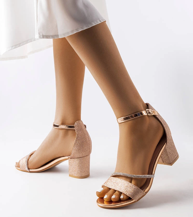 Błyszczące złote sandały na słupku
