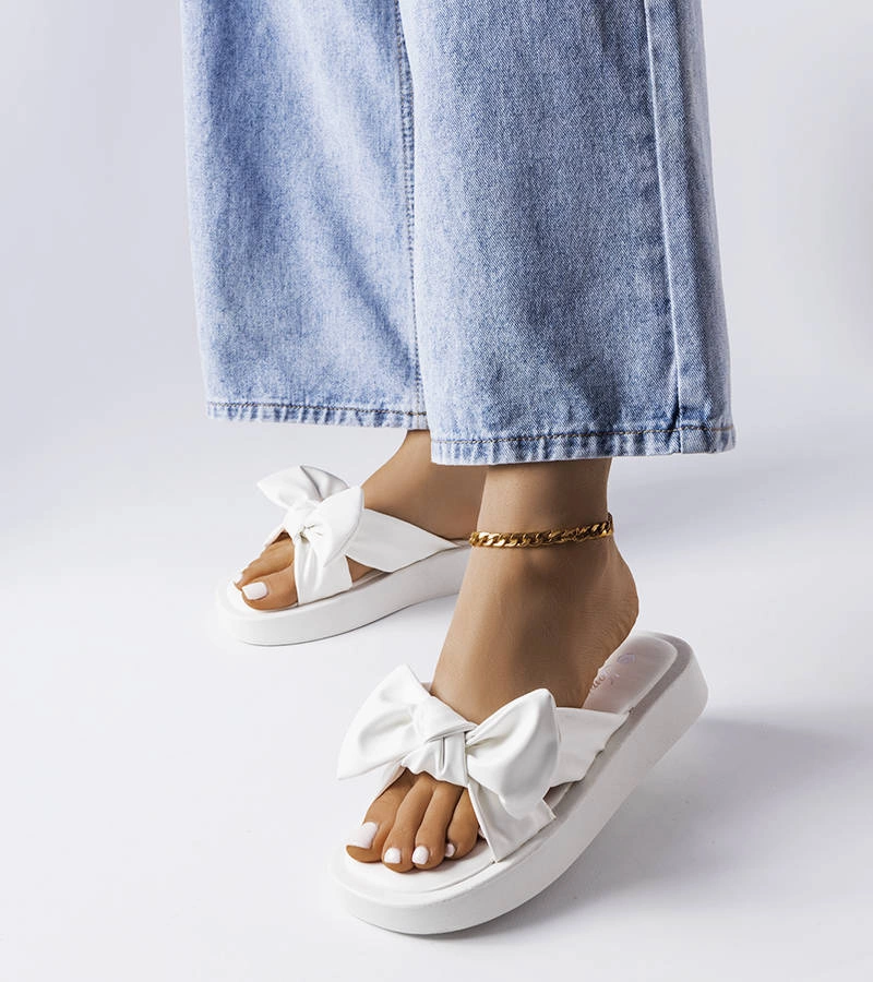 Białe klapki na platformie ozdobione kokardką