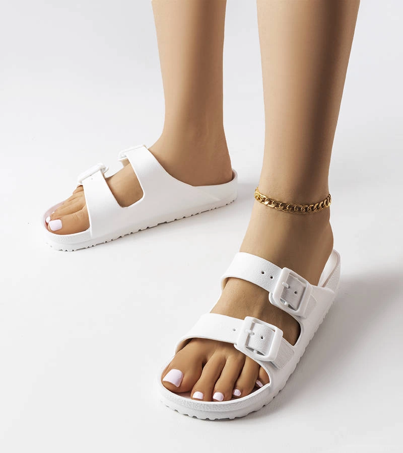 Białe klapki zdobione klamerkami