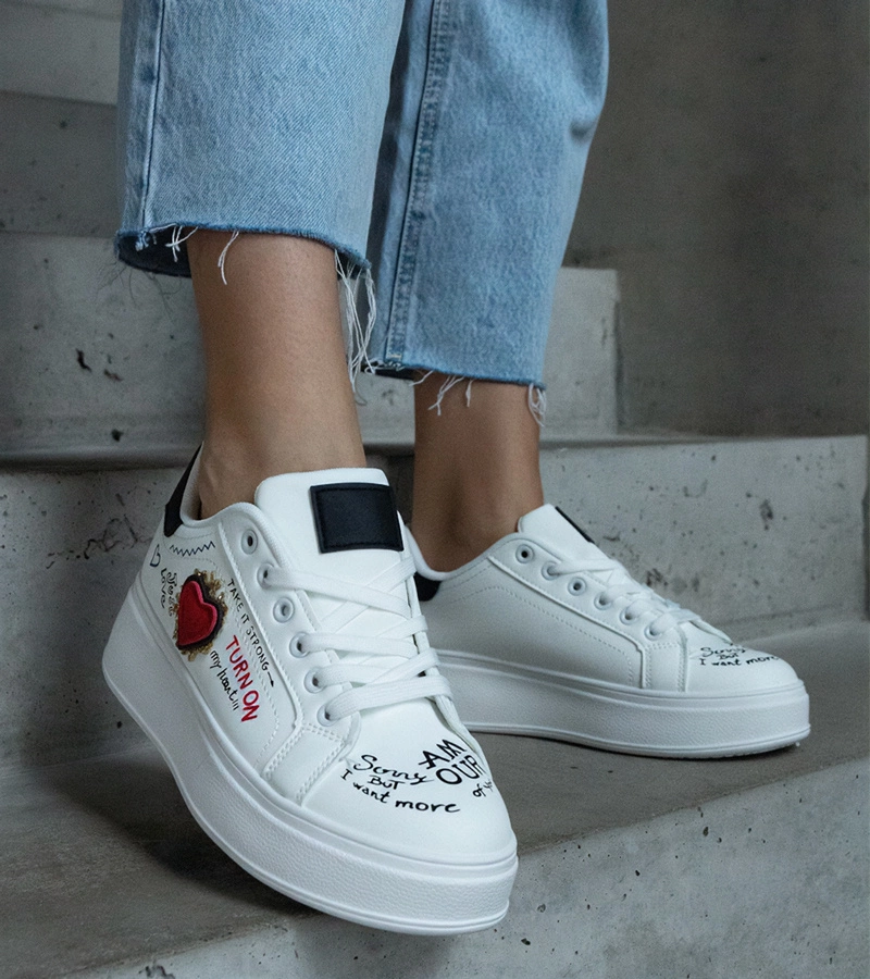 Białe sneakersy ozdobione naszywką i napisami na platformie