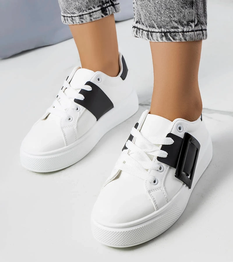 Białe sneakersy zdobione czarną klamerką
