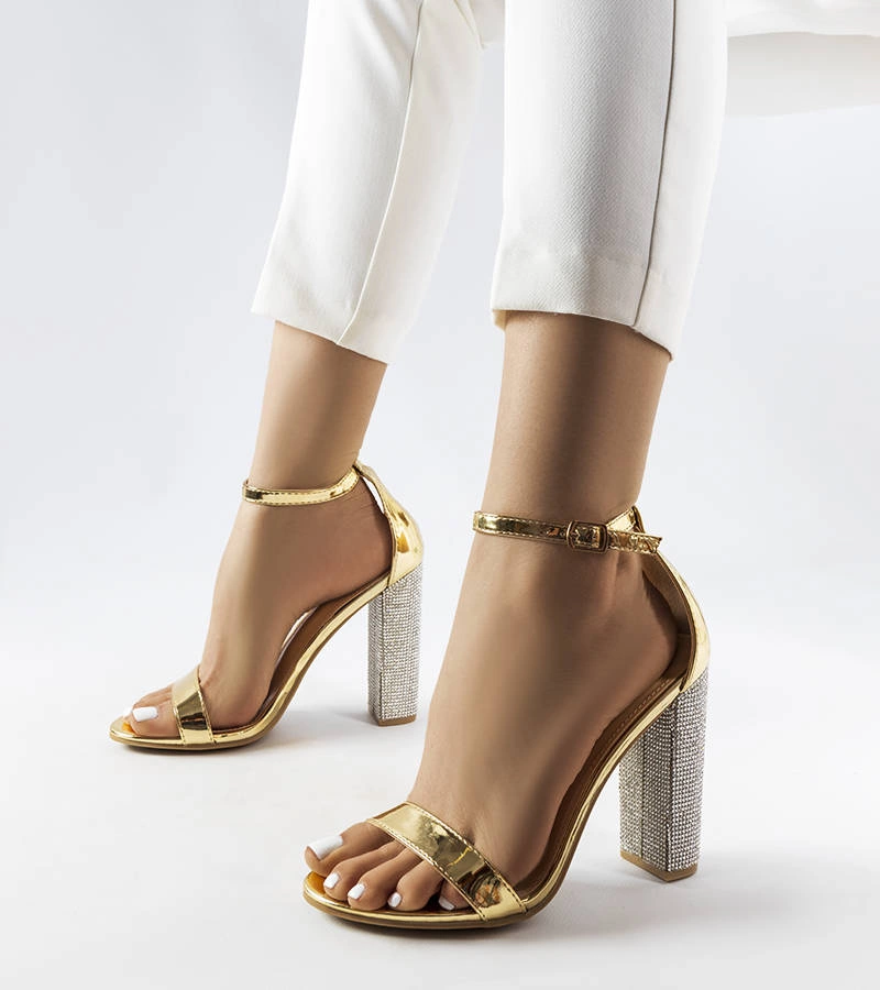 Złote eleganckie sandały na słupku