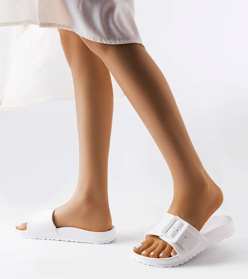 Białe klapki zdobione klamerką